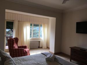 1 dormitorio con 1 cama, 1 silla y 1 ventana en Gran Hotel La Cumbre en La Cumbre