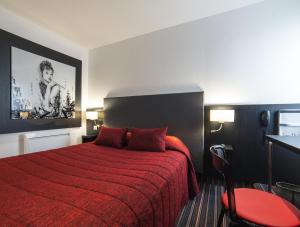 a hotel room with a red bed with a red blanket at Cit'Hotel Stim'Otel in Agen