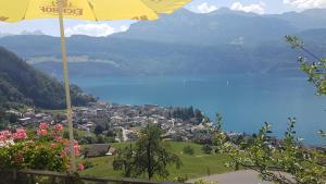 una sombrilla amarilla con vistas a la ciudad y al lago en Gasthaus Platten en Gersau