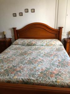 - une chambre dotée d'un lit avec un couvre-lit floral dans l'établissement Bilocale Mirella, à Carro