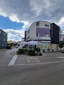 a building with a parking lot in front of it at Apartman Nikos in Zadar