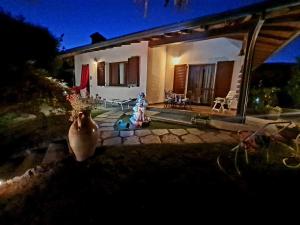 B&B Margot في Albavilla: منزل أمامه مزهرية في الليل