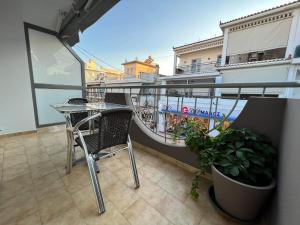 a balcony with a table and chairs and a boat at ATLANTIS APARTMENTS in Artemida