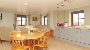 a kitchen and living room with a table and chairs at Parkfields Barns Self Catering Accommodation in Buckingham