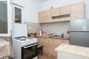 a kitchen with a white stove and a refrigerator at Apartment Tanja in Mrčevac