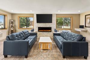 uma sala de estar com dois sofás e uma lareira em Super 8 by Wyndham Ankeny/Des Moines Area em Ankeny