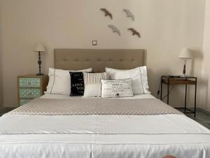 a bedroom with a large bed with birds on the wall at Aelia Houses in Agia Marina Aegina