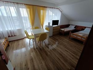 a room with a table and chairs and a bedroom at Pokoje Gościnne u MARCINA- sala zabaw, basen, melex, rowery, grill in Ostrowo