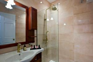 a bathroom with a shower and a sink and a mirror at History House in Corfu Town