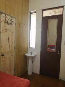 baño con lavabo, espejo y puerta en Hotel Metropolitano, en Guatemala