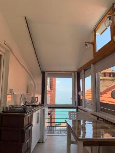 a kitchen with a table and a large window at Stojanoski Studios & Rooms in Trpejca