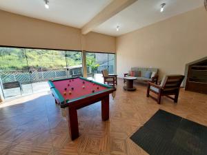 um quarto com uma mesa de bilhar numa sala de estar em Recanto Serra Negra - Sossego e lazer! em Serra Negra