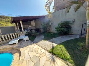 a backyard with a swimming pool and a house at Recanto Serra Negra - Sossego e lazer! in Serra Negra