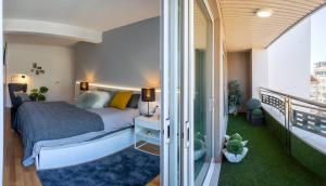 a bedroom with a bed and a balcony at Impresionante apartamento en Plaza de Galicia in Vilagarcia de Arousa