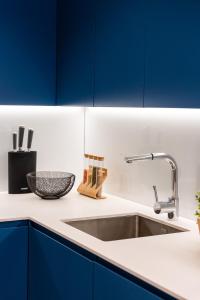 a kitchen with blue cabinets and a sink at Impresionante apartamento en Plaza de Galicia in Vilagarcia de Arousa