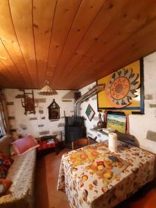 a living room with a table and a stove at Piccola oasi nella frescura delle Alpi tra verdi boschi e sorgenti di acqua purissima in Vanzone