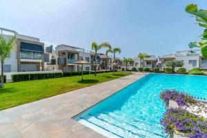 Una vista exterior de una villa con piscina. en Espanhouse Caroline bungalow, en Torrevieja