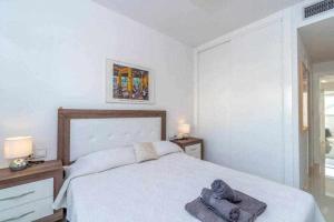 Un dormitorio blanco con una cama con toallas. en Espanhouse Caroline bungalow, en Torrevieja 42 fotos más