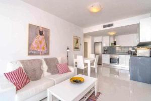 Una sala de estar con un sofá y una mesa y una cocina. en Espanhouse Caroline bungalow, en Torrevieja