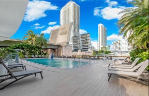 a swimming pool with lounge chairs and buildings at Studio apartment with an incredible view- 14 in Hallandale Beach