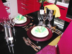 a table with two plates and wine glasses on it at Appartamento Residence Canalotto in Realmonte
