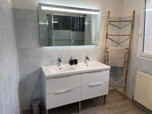 La salle de bains est pourvue d'un lavabo blanc et d'un miroir. dans l'établissement La maison bleue, à Lautrec