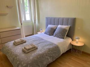 1 dormitorio con 1 cama con 2 toallas en La maison bleue, en Lautrec