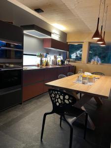 a kitchen with a wooden table with a chair in it at Chalet Dachstein in Ramsau am Dachstein