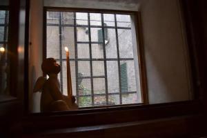 una candela seduta sul davanzale di una finestra con una candela di Monolocale Rustico Mamma Piera a Manciano