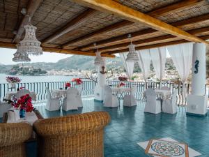 un salón de banquetes con mesas y sillas blancas en B&B Alta Marea Lipari, en Lipari