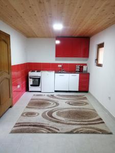 a kitchen with red cabinets and a carpet on the floor at GAGO’S WOODEN HOUSE in Plav