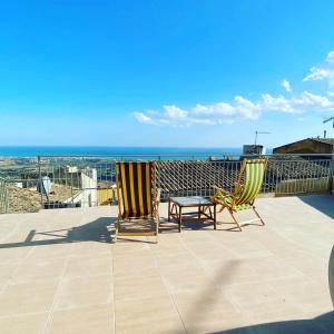 two chairs and a table on a balcony with the ocean at Greek Temple in Agrigento