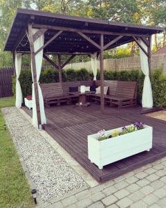 a wooden gazebo with a bench and a table at Miera osta in Kocēni