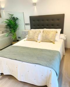 um quarto com uma grande cama branca com almofadas em Precioso estudio en castro urdiales em Castro-Urdiales