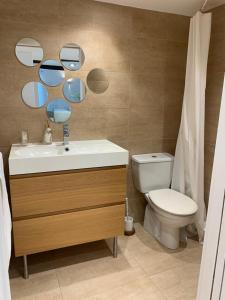 uma casa de banho com um lavatório, um WC e um espelho. em Precioso estudio en castro urdiales em Castro-Urdiales