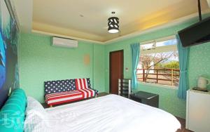 a bedroom with a bed and a chair in it at Miaoli Sanyi Bo Wu Guan Homestay in Sanyi