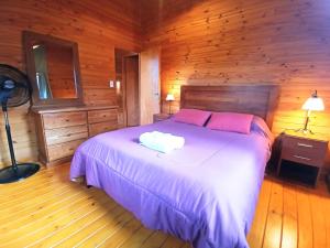 a bedroom with a bed in a wooden cabin at Cabañas El Refugio de Puelo in Lago Puelo