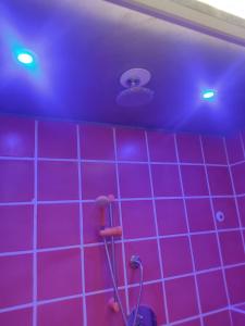 uma casa de banho com paredes em azulejo roxo e um tecto roxo em Elvis - Marilyn - Vasco Rossi - Airport Catania Center em Catânia