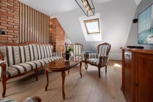 uma sala de estar com um sofá, uma mesa e cadeiras em Róża Bałtyku - Apartamenty i Pokoje em Dębki