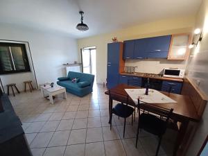 eine Küche und ein Wohnzimmer mit einem blauen Sofa in der Unterkunft la Cambuse in Torre Pellice