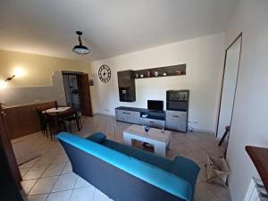 ein Wohnzimmer mit einem blauen Sofa und einem Tisch in der Unterkunft la Cambuse in Torre Pellice