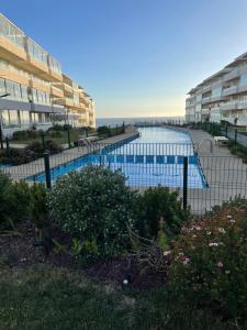 a swimming pool in front of some apartment buildings at Departamento con Vista Al Mar in El Tabo