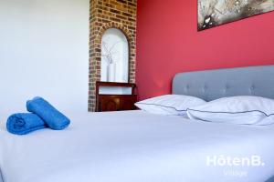 łóżko z białymi poduszkami i niebieskim ręcznikiem w obiekcie Grande maison de 140 m2 avec jardin ! 5 chambres w mieście Limoges