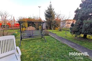 un parque con un banco blanco en el césped en Grande maison de 140 m2 avec jardin ! 5 chambres en Limoges