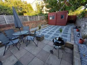 a patio with a grill and a table and chairs at Edwardian 5 bedroom townhouse, next to underground in London