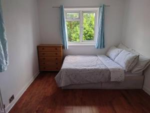 Habitación pequeña con cama y ventana en Edwardian 5 bedroom townhouse, next to underground, en Londres