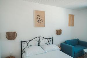 sypialnia z łóżkiem i niebieskim krzesłem w obiekcie FKK Ada Bojana w Ulcinju