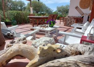 a patio with a table and chairs and flowers at Arcamyrtus in Alghero