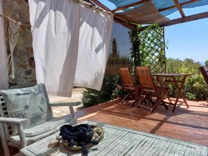 a patio with three chairs and a table at Arcamyrtus in Alghero