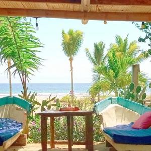 eine Terrasse mit Tisch und Stühlen sowie Strand in der Unterkunft Café Madame in Puerto López